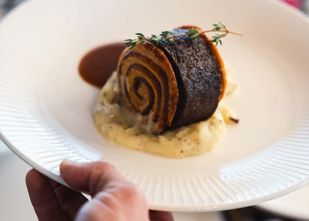 Un camarero sirviendo el mismo plato que ha terminado el chef
